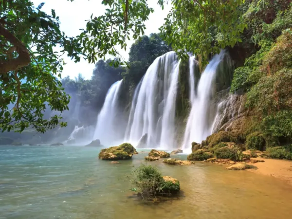 Ban Gioc Waterfall cascading through lush forest in Cao Bang