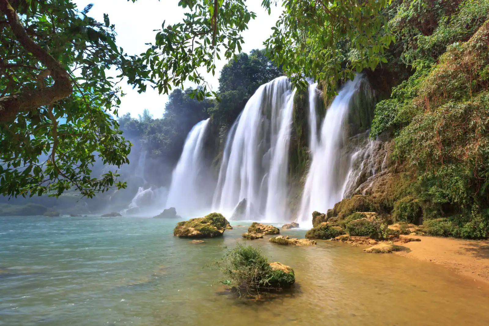 Ban Gioc Waterfall cascading through lush forest in Cao Bang