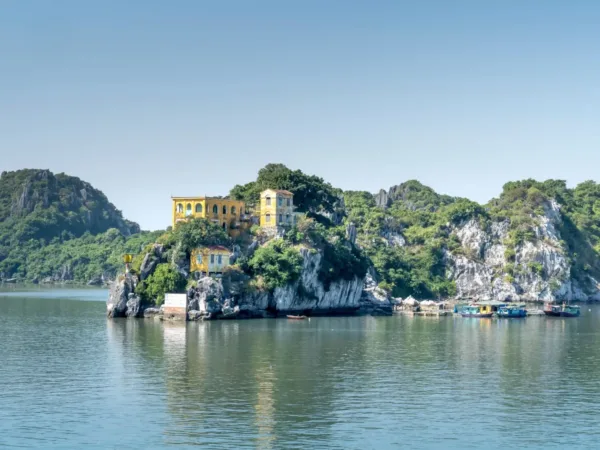 Yellow colonial house perched on a cliff over Lan Ha Bay, Cat Ba