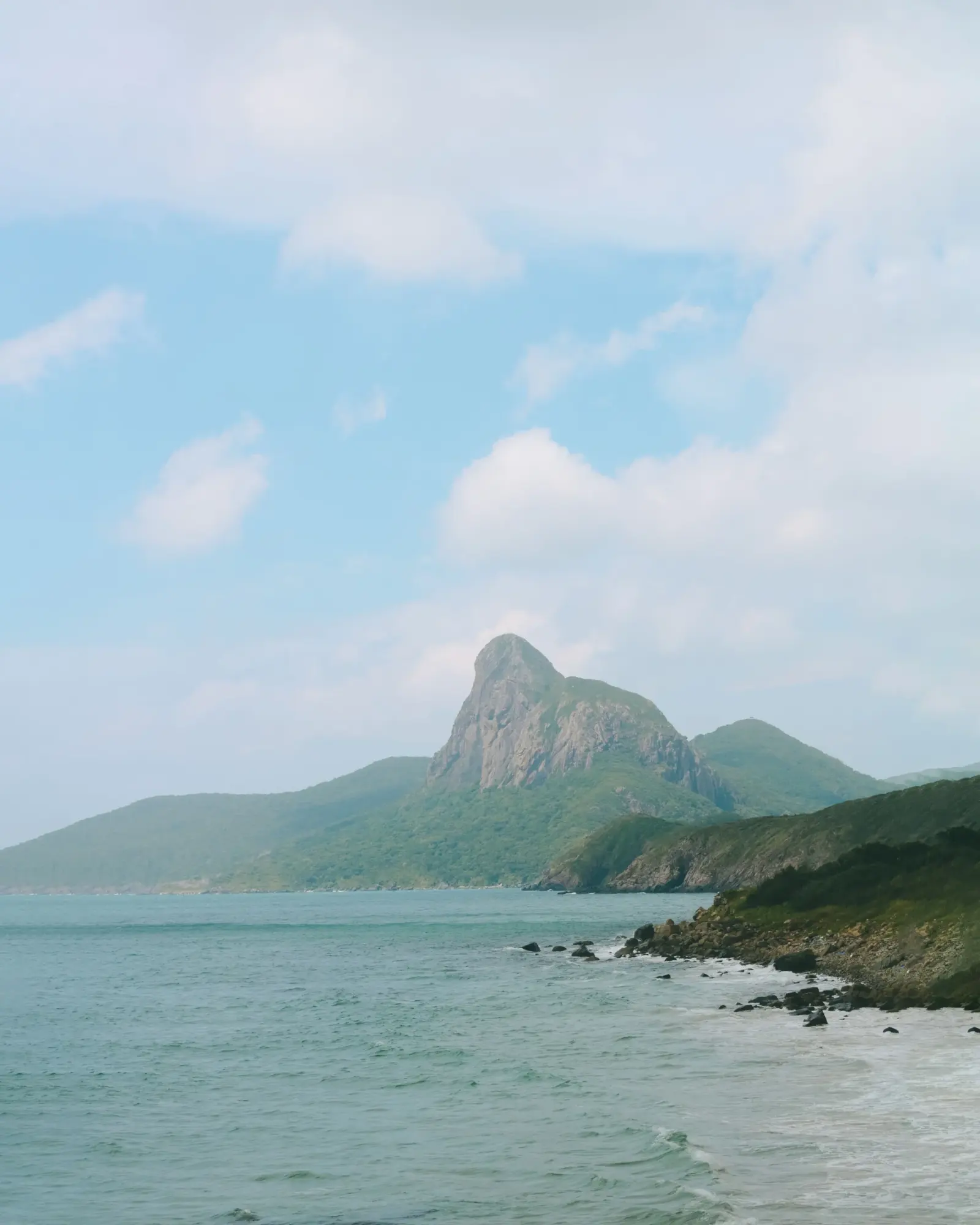 A dramatic rocky peak rising above the coastline of Con Dao island