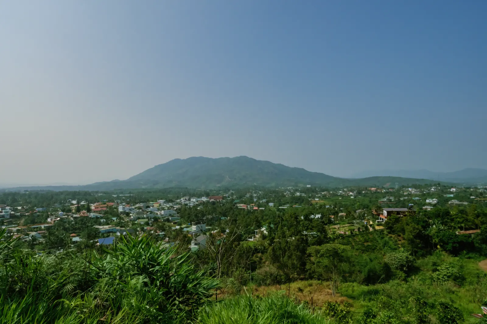 Countryside with mountains, a village and blue sky in the Central Highlands