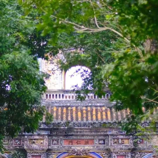 Historic gate framed by trees in Hue