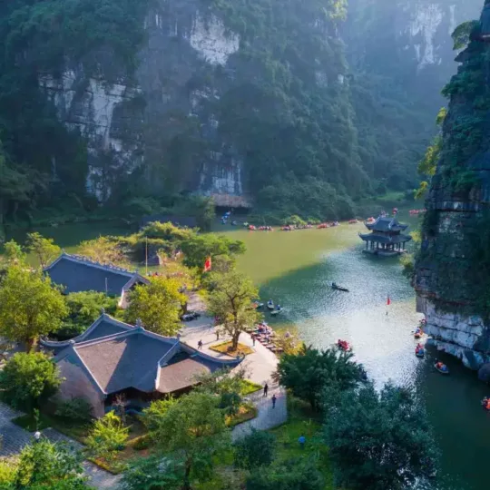 Ninh Binh weather guide showing boat tours along green rice paddies and limestone karsts