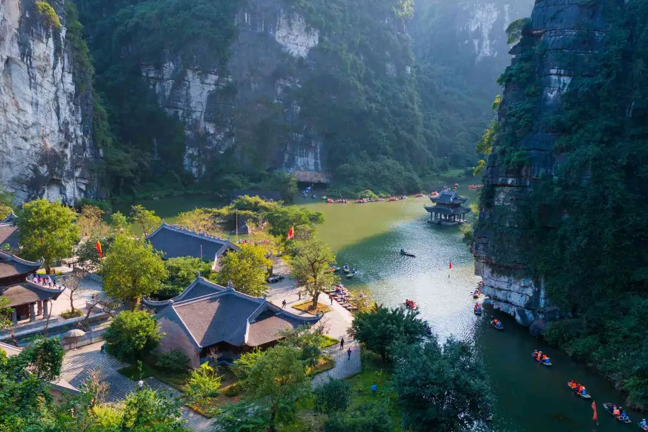 Ninh Binh weather guide showing boat tours along green rice paddies and limestone karsts