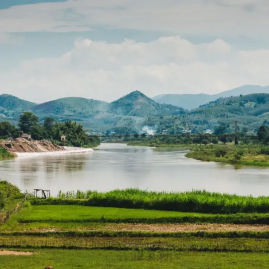 A calm river winding through green hills and rice fields near Pleiku, Gia Lai