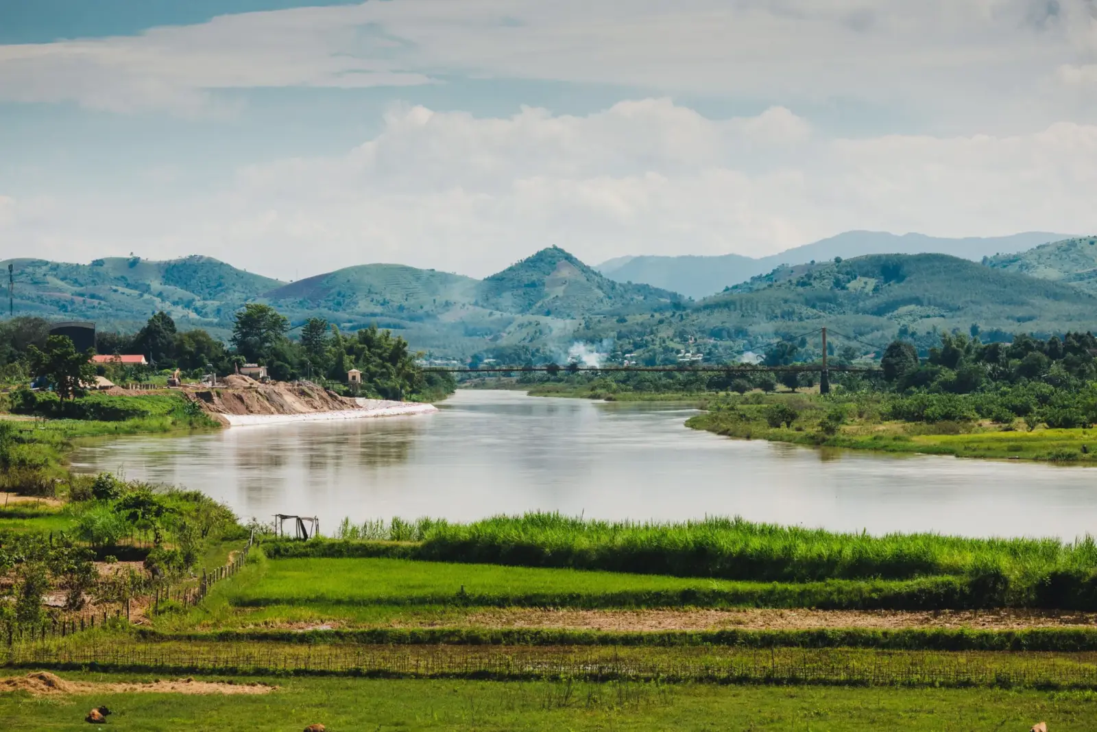 A calm river winding through green hills and rice fields near Pleiku, Gia Lai