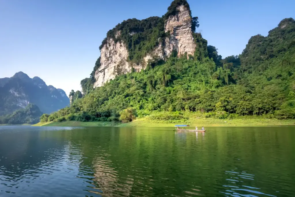 越南北𣴓省Ba Be湖的廣角景觀，石灰岩懸崖與綠色森林倒映在水中。