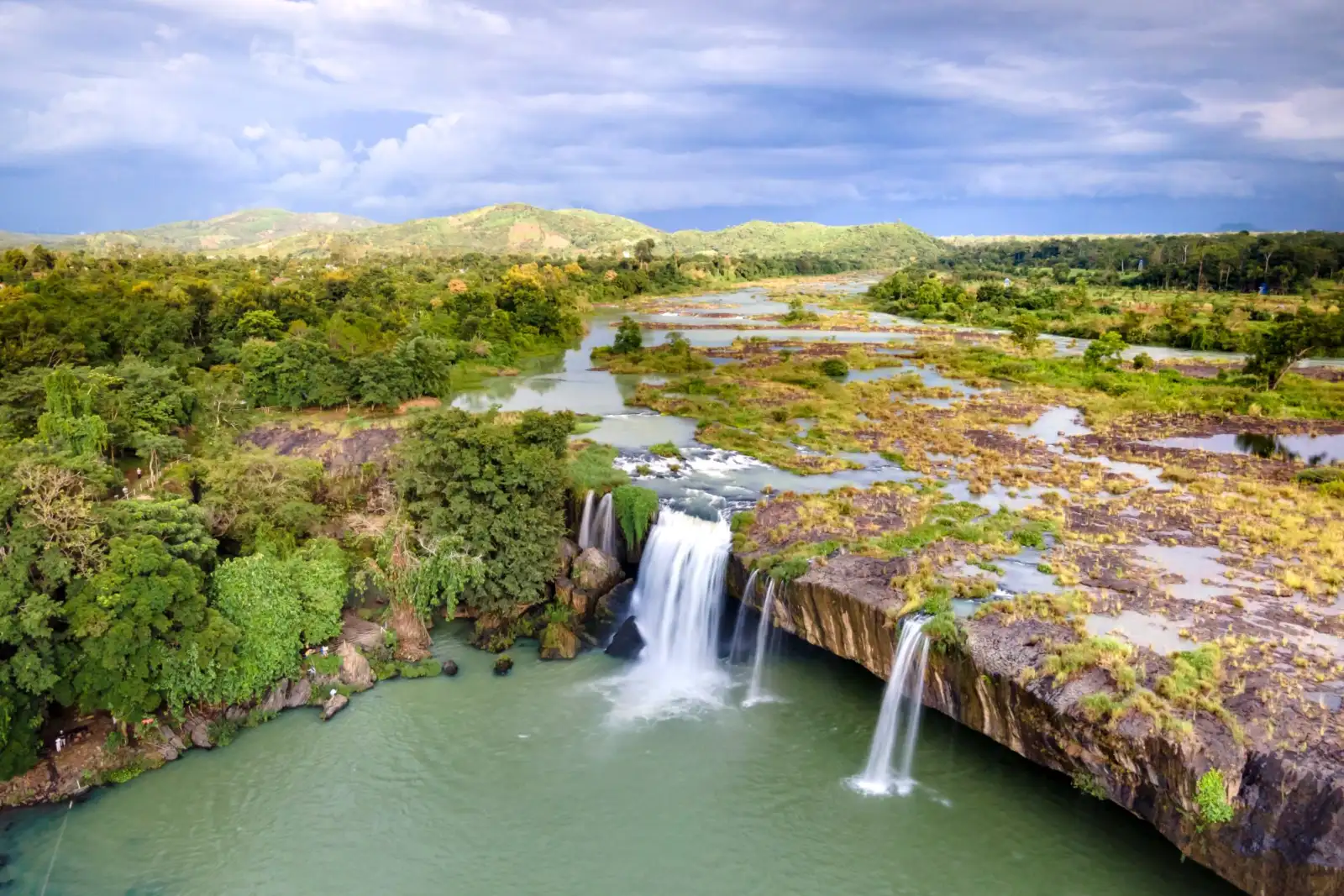 An aerial view of the cascading Dray Nur Waterfall surrounded by dense tropical greenery near Buon Ma Thuot, Vietnam.