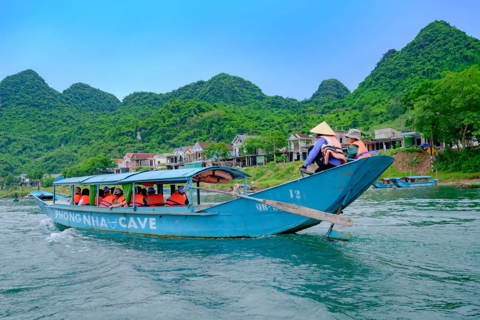 Tourists on a small boat traveling through the limestone formations of Phong Nha Cave in Phong Nha Ke Bang National Park.