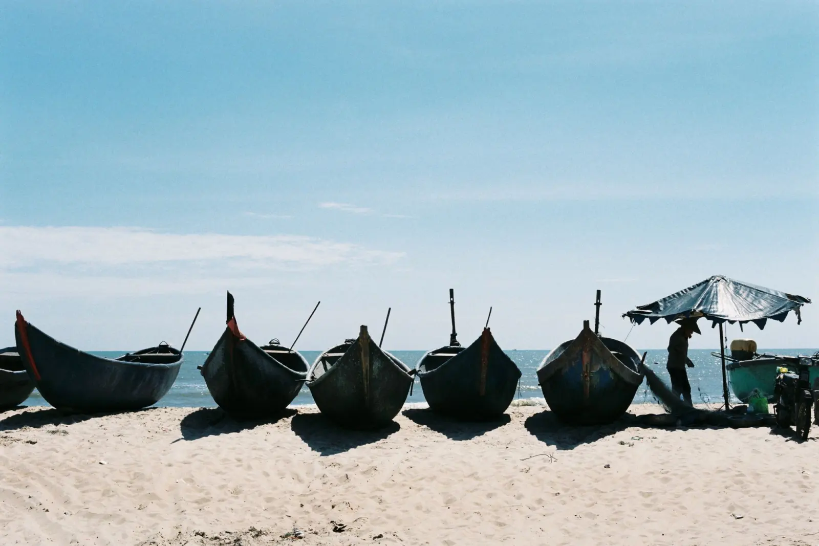 Fishing boats lined up on the serene sands of Back Beach in Vung Tau, Ba Ria-Vung Tau province, Vietnam.
